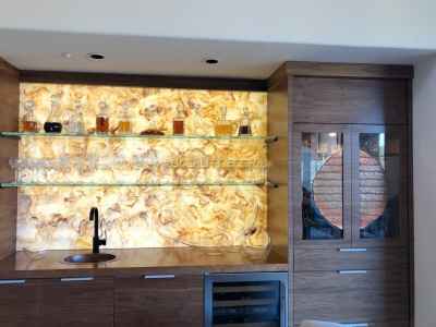 Walnut cabinetry illuminating this bar wall feature